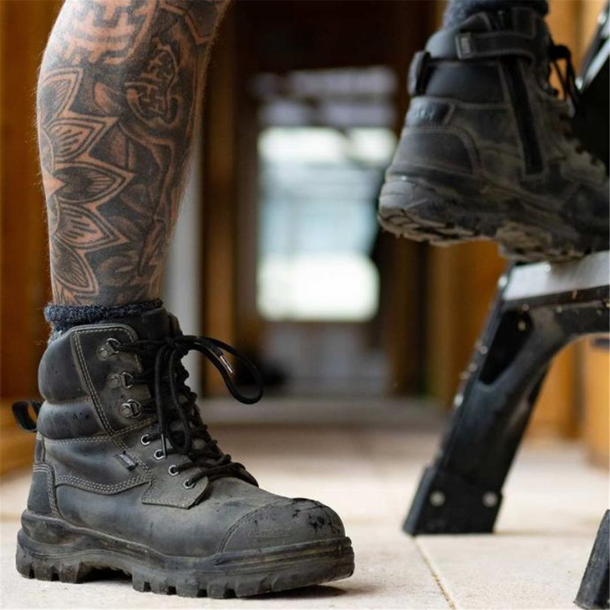 A tradie wearing black Blundstone 8071 Rotoflex safety boots while working on a construction site.